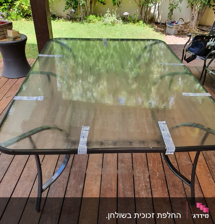 שולחן זכוכית עם מדבקות על משטח עץ